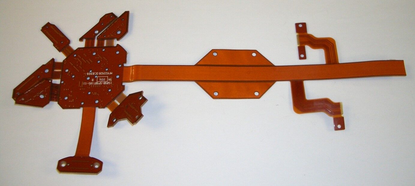 Orange flexible circuit board with multiple connectors.