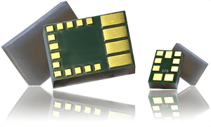Close-up of electronic microchips with gold contact pads on a reflective surface.