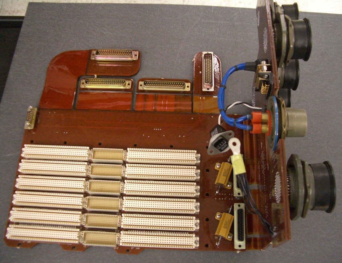 Close-up of an old electronic circuit board with capacitors and wires.